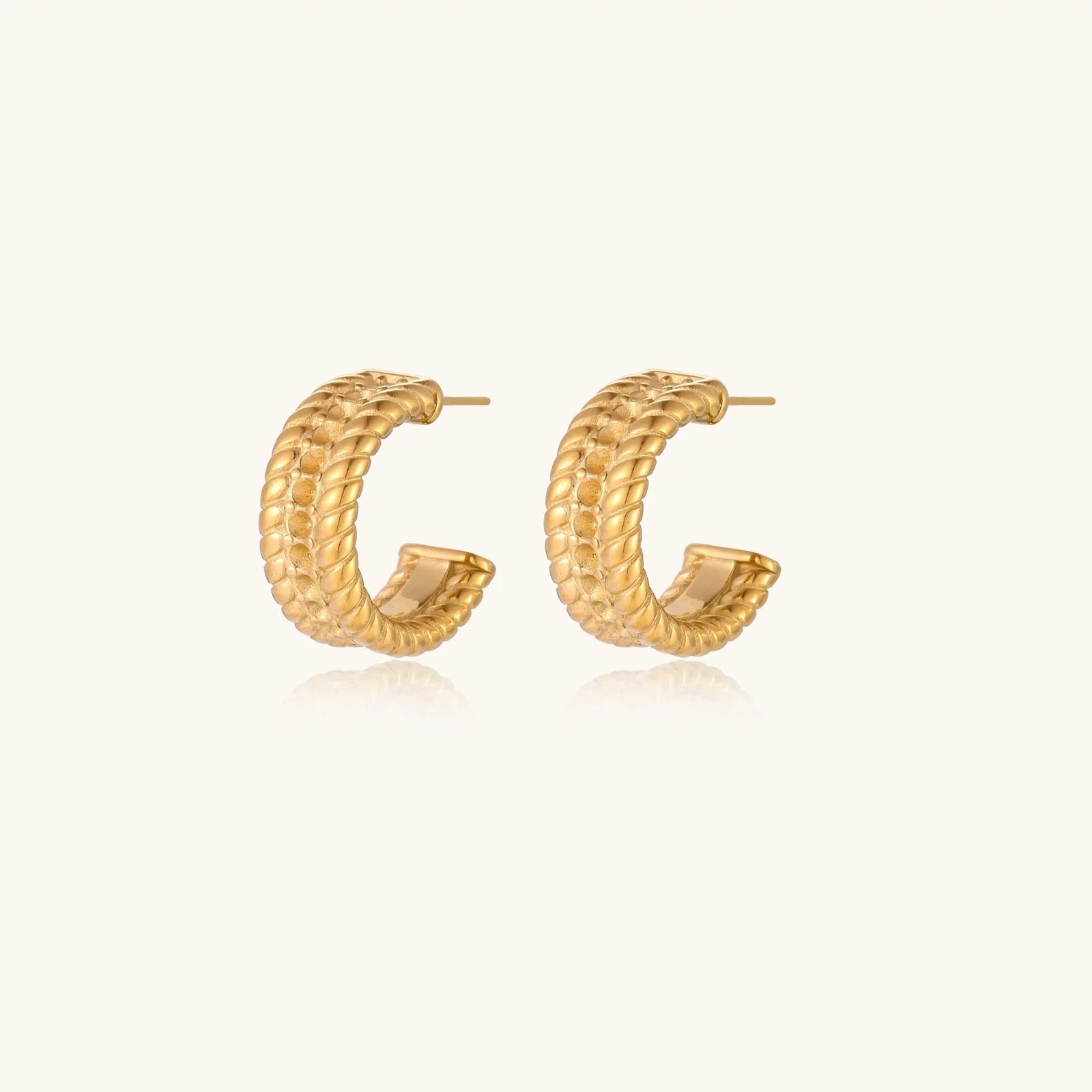 Chunky gold hoops with dimensional ridged texture and 14K plated finish shown in front and side view on cream background.